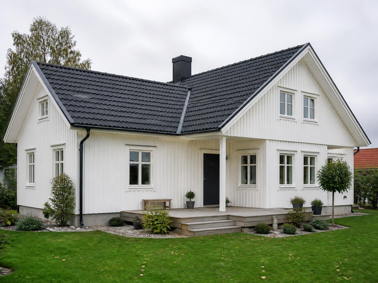 Illustrationsbild: vit svensk villa med mörkt betongpannetak och plåtdetaljer